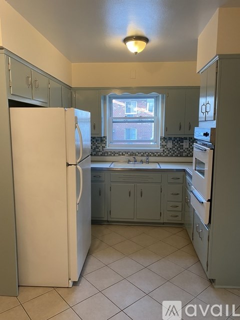 A kitchen with a white refrigerator and a window.