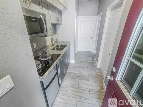 A kitchen with a white counter top and a stove top oven.
