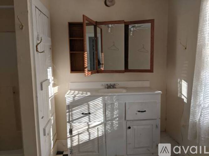 A bathroom with a white vanity and a mirror above it.