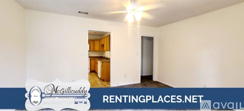 A room with a window and a carpeted floor is available for rent.