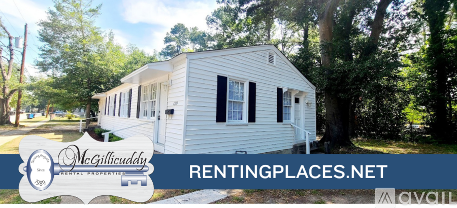 A white mobile home is for rent in a wooded area.