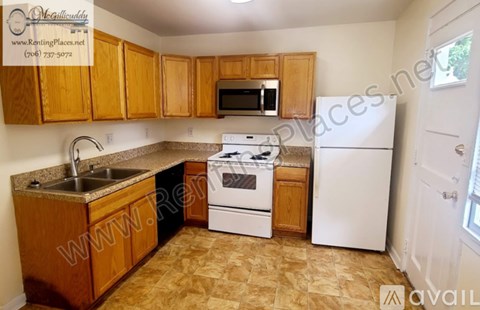 A kitchen with wooden cabinets and a white refrigerator.