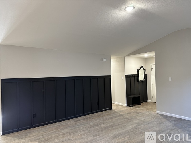 A room with a long black wardrobe and a small black shelf.
