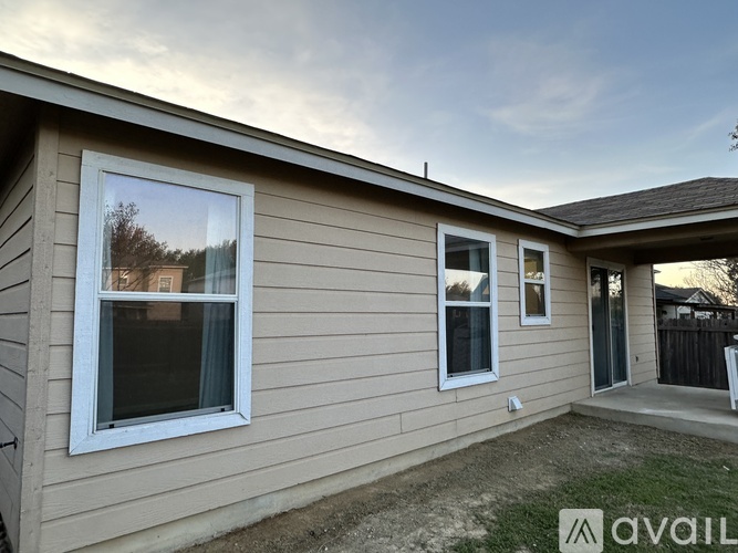 A house with a beige exterior and a large window on the left side.