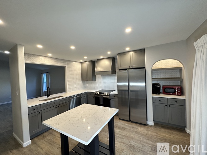 A modern kitchen with a central island and stainless steel appliances.