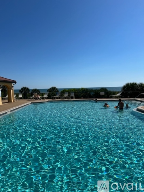 A group of people are swimming in a blue pool.