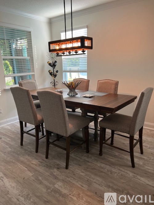 A dining room with a table and chairs.