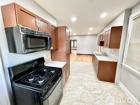 A kitchen with a black stove top oven and a black microwave above it.
