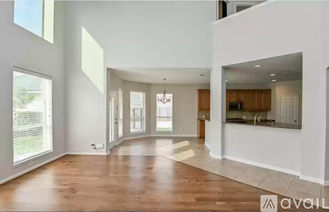 A spacious living room with wooden floors and white walls.