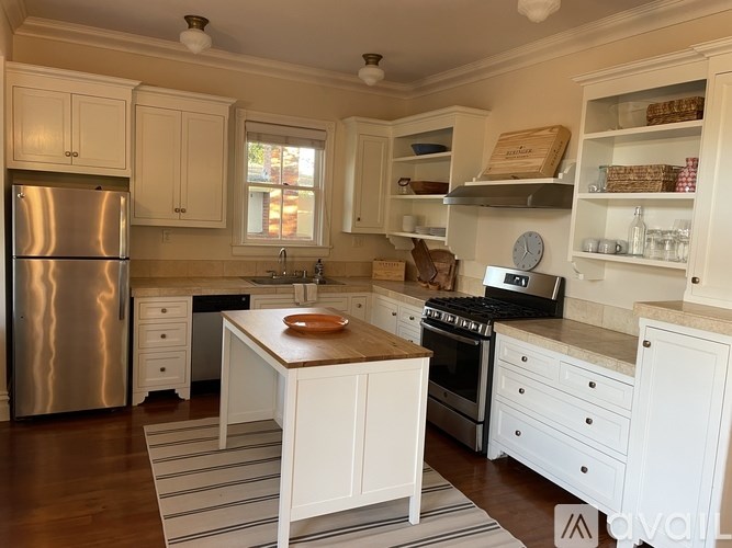 A kitchen with white cabinets and a wooden island.