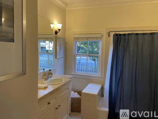 A bathroom with a sink, mirror, and window.