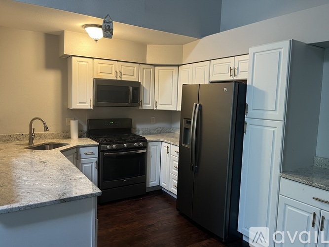 A kitchen with black appliances and white cabinets.
