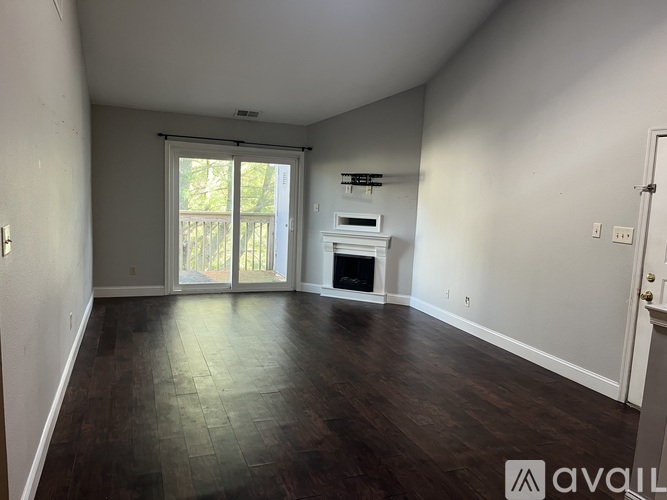 A spacious room with wood flooring and a fireplace.