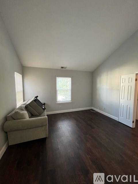 A living room with a couch and a window.