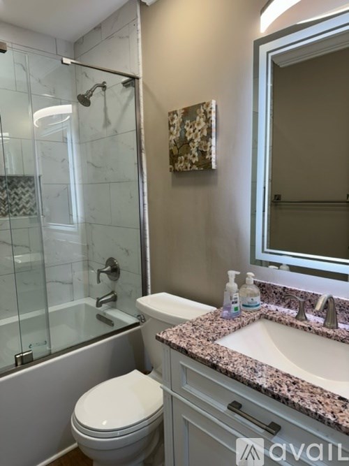 A bathroom with a toilet, sink, and shower.