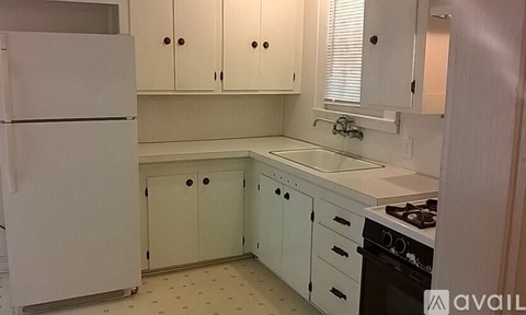 A kitchen with white cabinets and appliances.