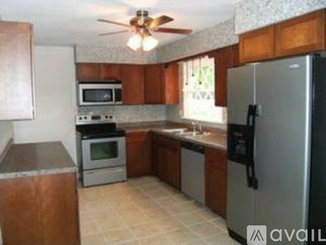A kitchen with a refrigerator, oven, microwave, and sink.