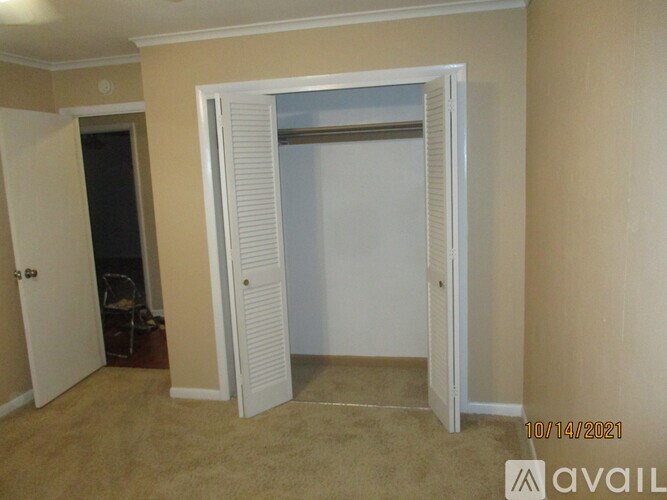 A room with a carpeted floor and a white door.