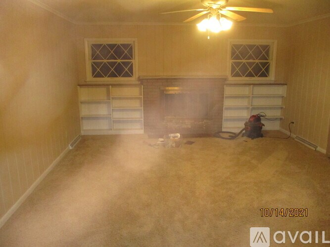 A room with a fireplace and a ceiling fan.