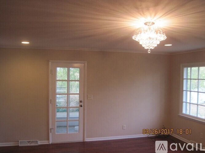 A room with a door and a chandelier.
