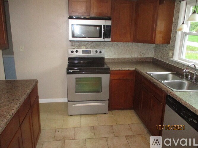 A kitchen with a stove, microwave, and oven.