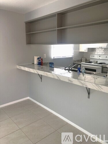 A kitchen with a marble countertop and a stove top oven.