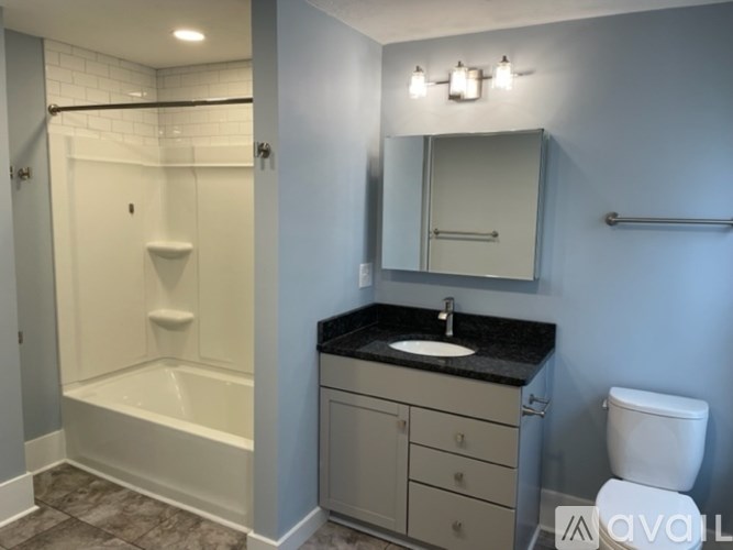 A bathroom with a white tub, sink, and toilet.