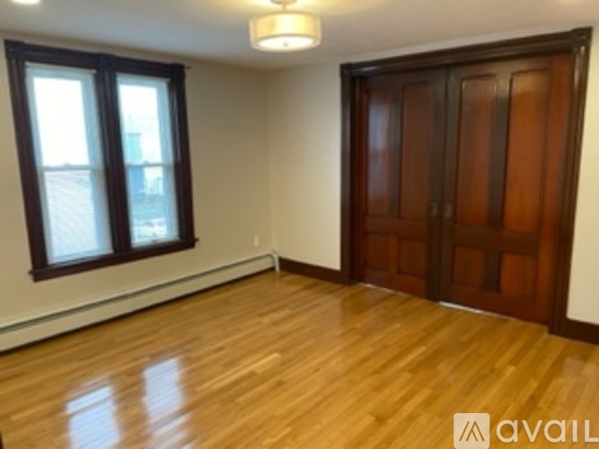 A room with wooden floors and a brown door.