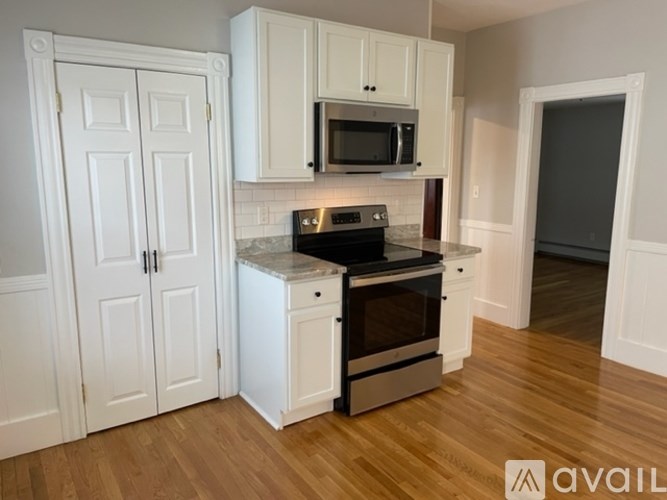 A kitchen with white cabinets and a black stove top oven.