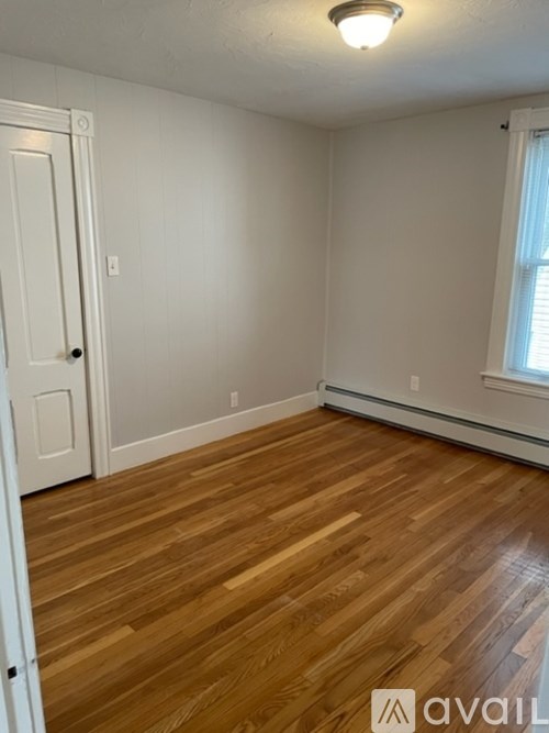 A room with wooden flooring and a white door.