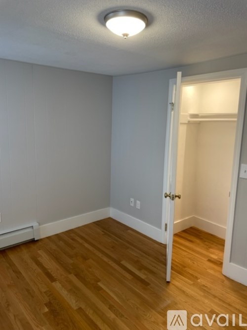 A room with a wooden floor and a white door.