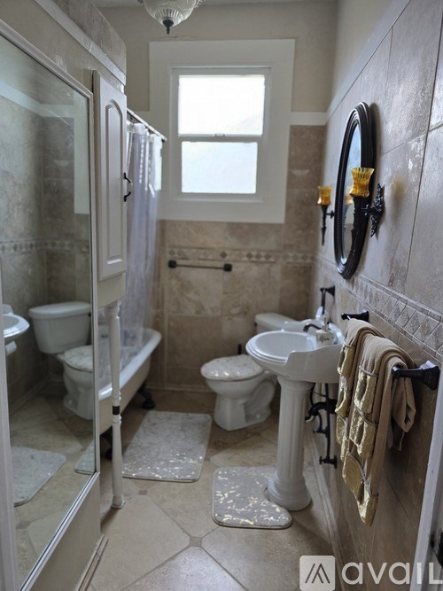 A bathroom with a toilet, sink, and shower.