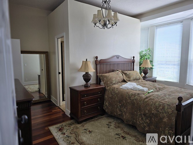 A bedroom with a bed, dresser, and mirror.