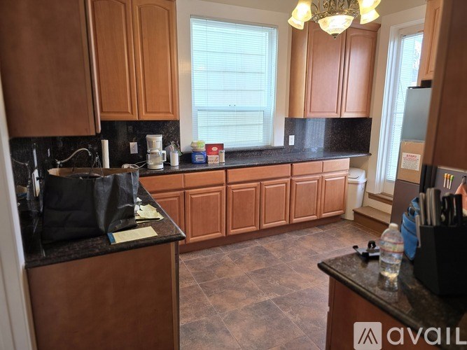 A kitchen with brown cabinets and black countertops.