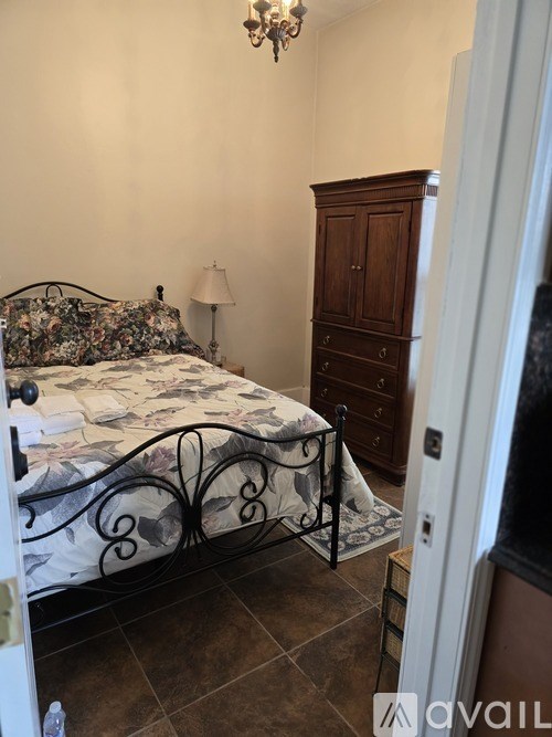 A bedroom with a bed, dresser, and lamp.