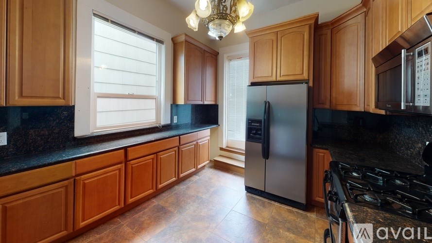 A kitchen with wooden cabinets and a black countertop.
