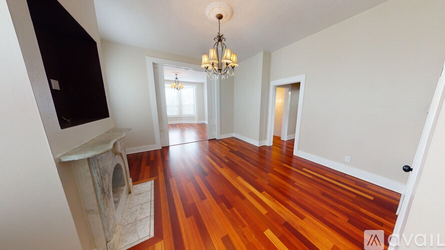 A living room with hardwood floors and a chandelier.