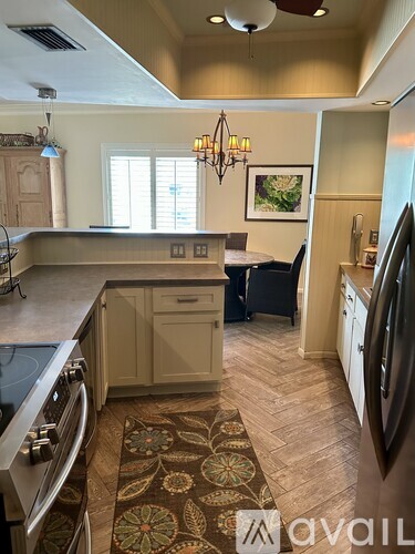A kitchen with a patterned rug on the floor.