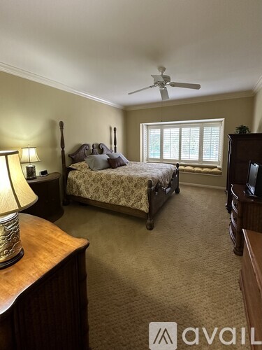 A bedroom with a bed, dresser, and ceiling fan.