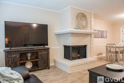 A living room with a fireplace and a television.
