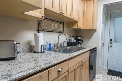A kitchen with wooden cabinets and granite countertops.