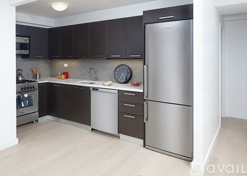 A modern kitchen with dark brown cabinets and stainless steel appliances.