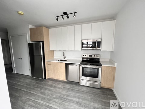 A modern kitchen with a stainless steel refrigerator, oven, and sink.