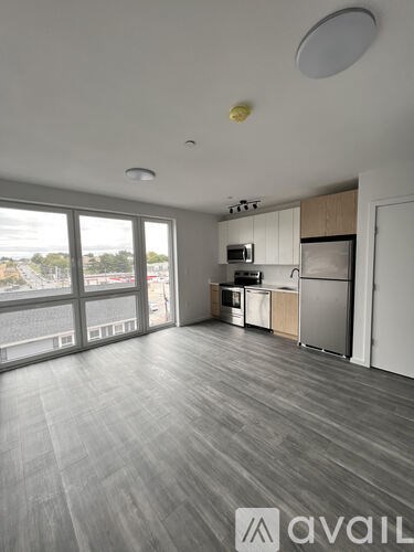 A spacious kitchen with wooden cabinets and a grey floor.
