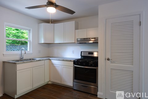 A kitchen with white cabinets and a stove top oven.