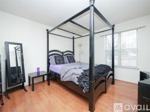 A bedroom with a four poster bed and a mirror.