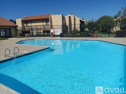 A swimming pool in front of a building with a sign that says "AVAIL".