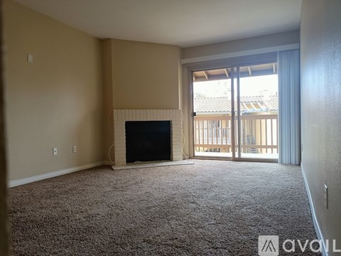 A living room with a fireplace and sliding glass doors.