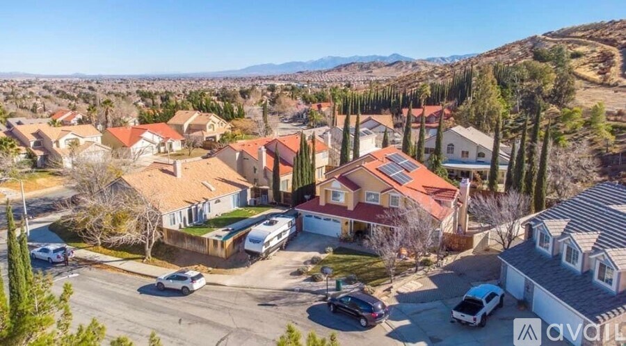 A sunny day in a residential area with houses and cars.