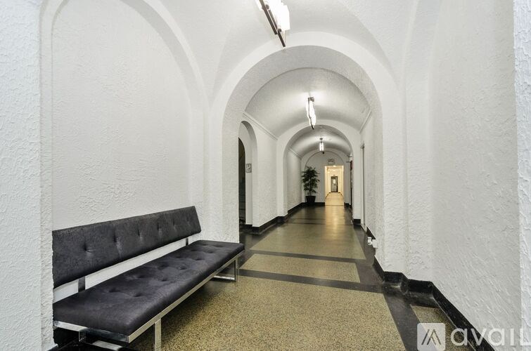 A long hallway with a bench on the left side.